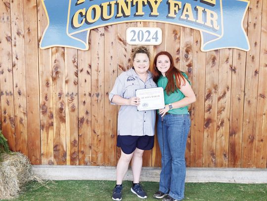 Olivia Hays presents Alaina Baker with the Kindness from Case belt buckle at the 2024 Freestone County Fair. Photo by Mitchell Pate/Fairfield Recorder