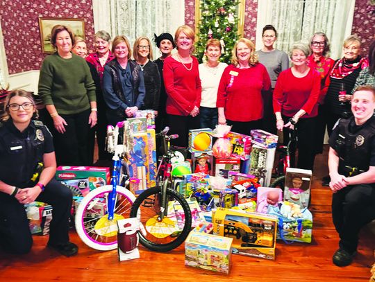 The Fairfield History Club presents Fairfield Police Department Officers Bailey Mills and Joshua Ashley with children’s gifts for Blue Santa on Thursday evening, Dec. 5, at the Moody Bradley House. Photo by Daryl Allen/Fairfield Recorder