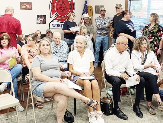 Wortham residents attending a special City Council meeting Monday, Aug. 12, where the recent, sudden retirement of longtime Chief of Police Kelly Butler was discussed, chat with each other during a closed session of the council. Photo by David Webb/The Mexia News
