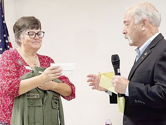 Ed Marcotte presents a check for $1,876 to Wreaths Across America Chair Beth Harrison that represents a donation from Limestone and Freestone Counties Masons for the organization’s work. Harrison holds a U.S. Army jacket worn by Marcotte’s uncle.
