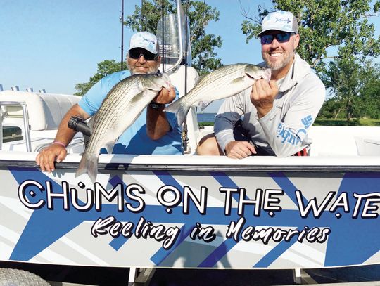 Brett Kilmer (left) and Casey Laughlin with Chums on the Water Guide Service show off a couple of hybrid stripers landed with Luke last week at Lake Tawakoni. Photo by Luke Clayton