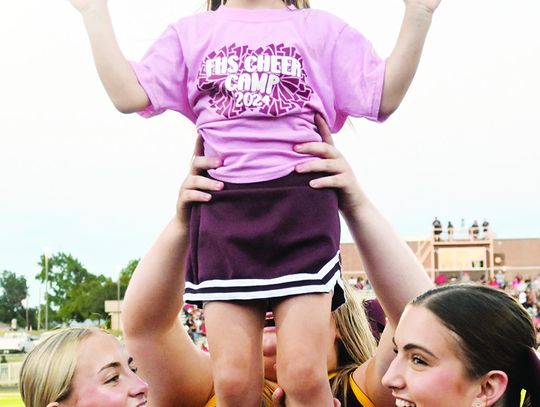 Delilah Phillips is boosted into the air by some high school cheerleaders. She was one of the many youngsters cheering on the Eagles against Mexia on Friday night. Photo by Mitchell Pate/Fairfield Recorder