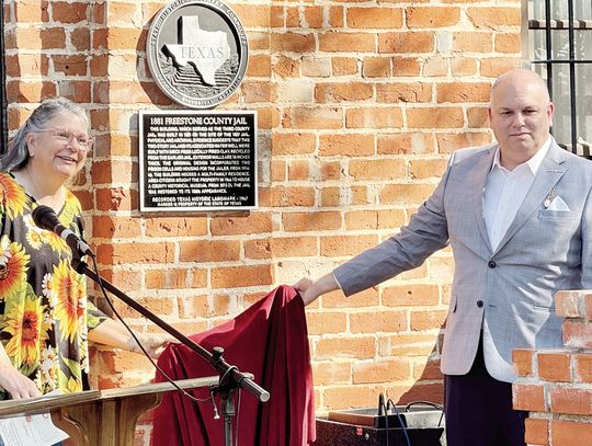 Freestone County Historical Museum President Linda Mullen, left, and Chairman of Freestone County Historical Commission William Shelton unveil the new historical marker at the 1881 Freestone County Jail on Saturday morning, Oct. 5. Photo by Daryl Allen/ Fairfield Recorder