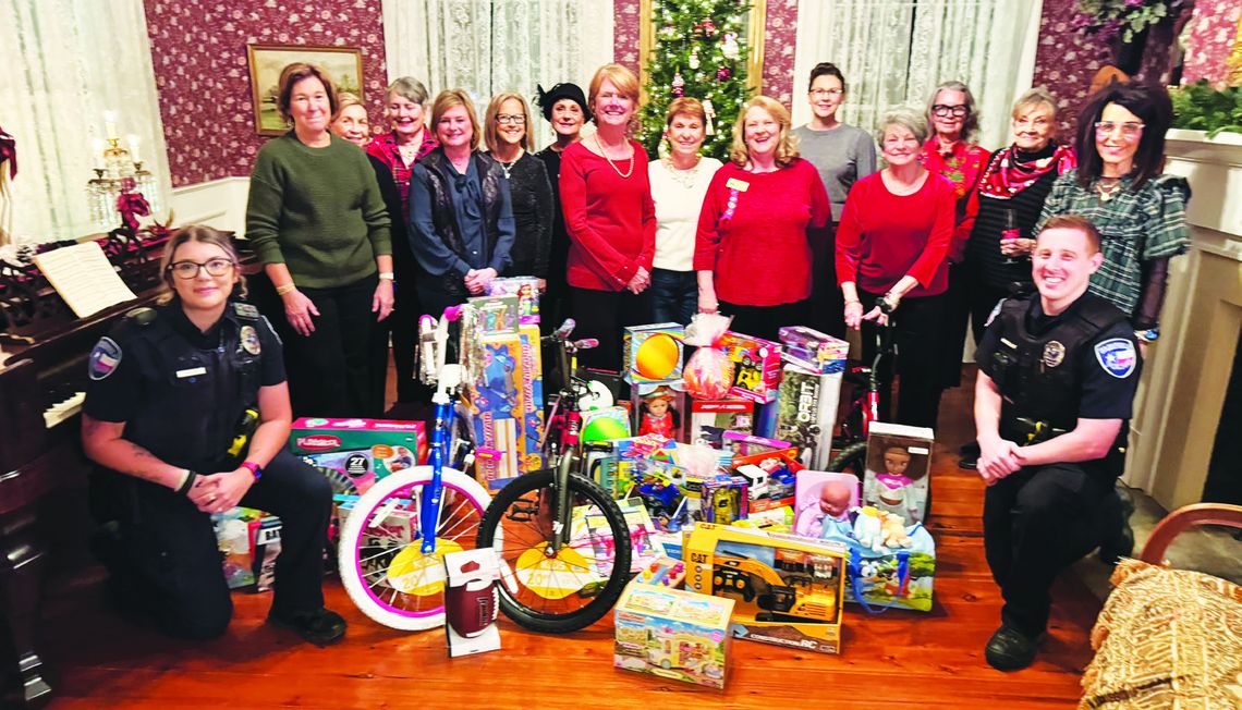 The Fairfield History Club presents Fairfield Police Department Officers Bailey Mills and Joshua Ashley with children’s gifts for Blue Santa on Thursday evening, Dec. 5, at the Moody Bradley House. Photo by Daryl Allen/Fairfield Recorder