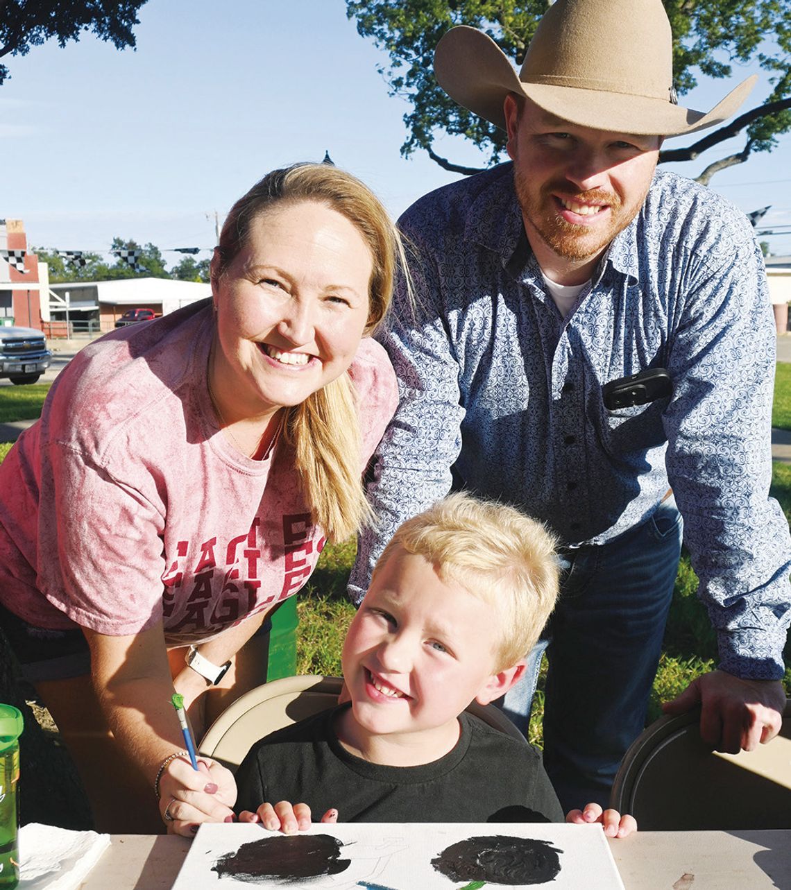 Painting with Picasso Five-year-old Connor Carroll shows off his painting with his parents Keith and Autumn Carroll.